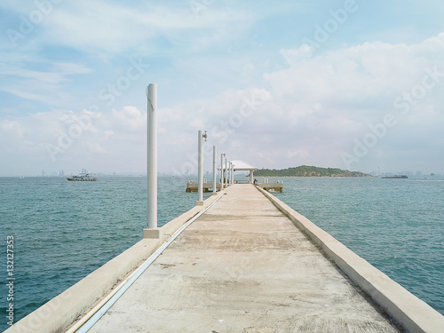 concrete pier on sea/ocean with blue sky background in Thailand.