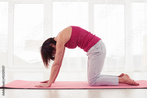 Female performing yoga pose on exercise mat