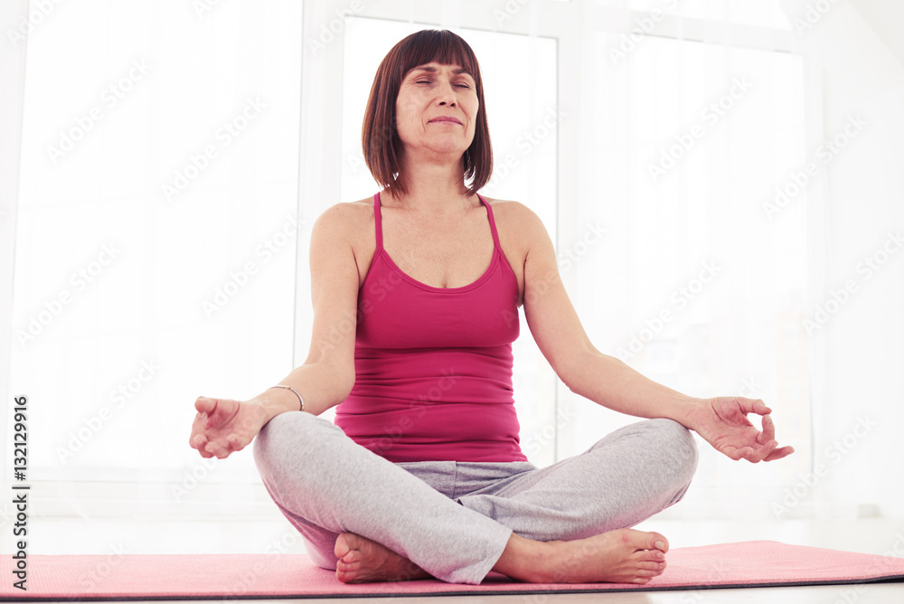 Low angle of harmonious woman relaxing while doing yoga pose in Low angle of harmonious woman relaxing while doing yoga pose in