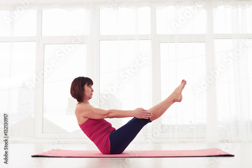 Sporty mature female doing ab crunches with legs raised into the