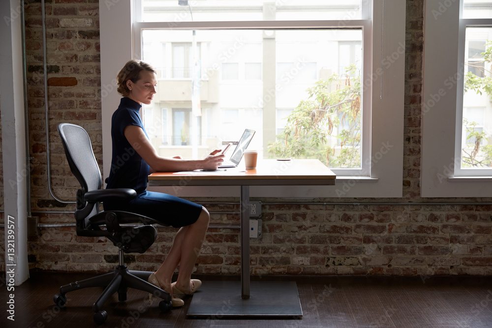 Businesswoman Working On Laptop And Checking Mobile Phone Businesswoman Working On Laptop And Checking Mobile Phone