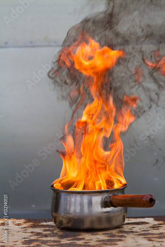 Vertical shot of saucepan on fire