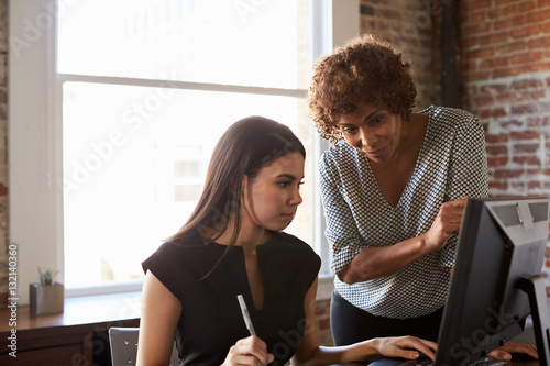 Two Businesswomen Working On Computer In Office photo