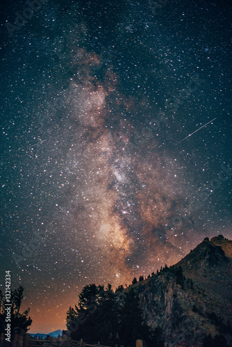 Milky way over mountain with shooting star