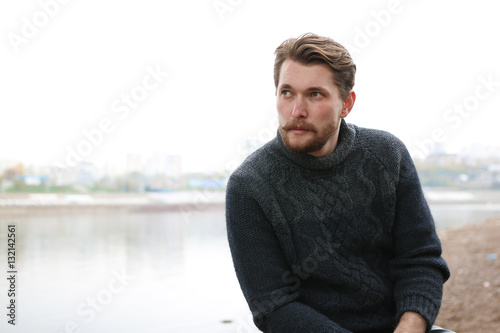 Handsome bearded man on the background of the river