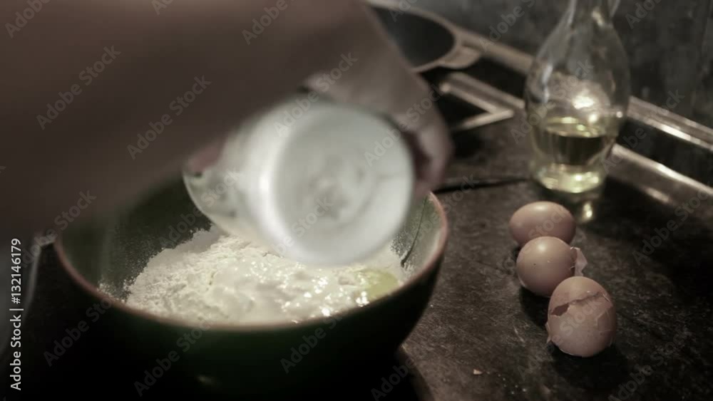 Cook mixes kefir with flour and eggs making dough for pancakes (low saturation)