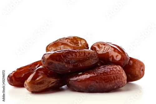 Close up of fresh brown dates against a white background 