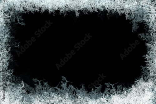 Frostwork. Decorative frostwork ice crystals frame on black background. Can be used as window frost overlay in design