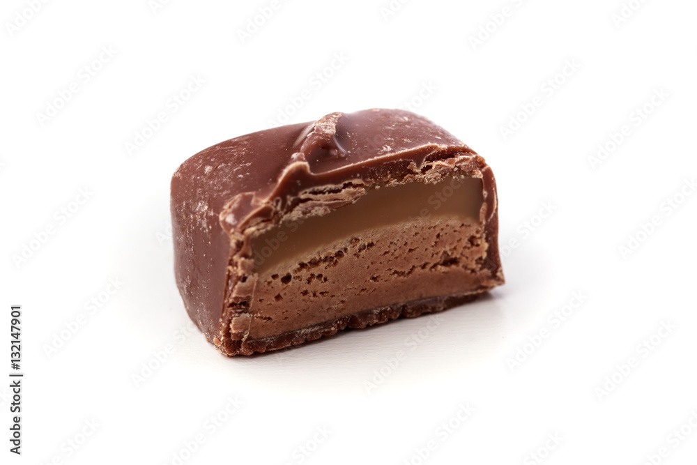 Closeup of single nougat chocolate with caramel on a white background Closeup of single nougat chocolate with caramel on a white background