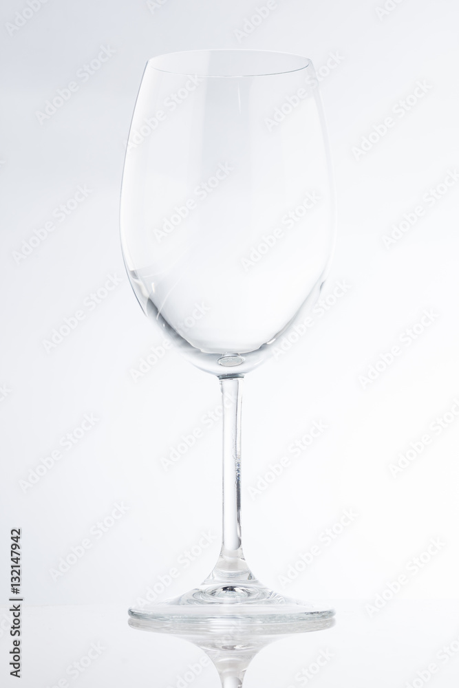 Tall empty wide wine glass with a thin stem on a white background