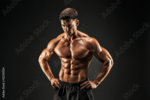 bodybuilder posing. Beautiful sporty guy male power. Fitness muscled man photo