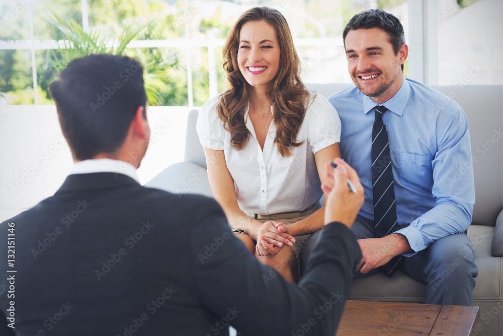 Smiling couple in meeting with a financial adviser - obrazy, fototapety, plakaty 