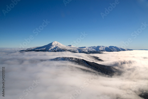 Panorama of winter mountain ridge on a background of blue sky. S
