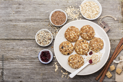 Multigrain Oatmeal cookies with flax seeds, sesame , dried cranberries, cane sugar on a ceramic dish   wooden background. Top view
