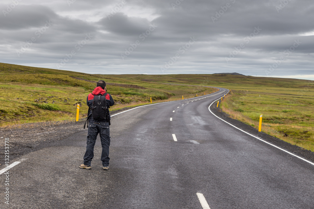 Man taking a picture of empty road on Iceland.
