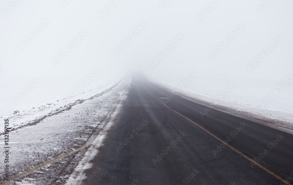 Snowstorm and poor visibility on the road, end is lost in the fog
