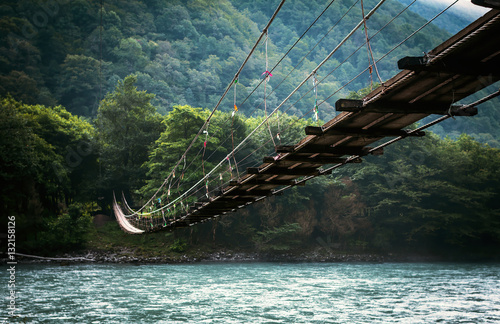 The bridge across the river. Natural landscape with mountains. photo