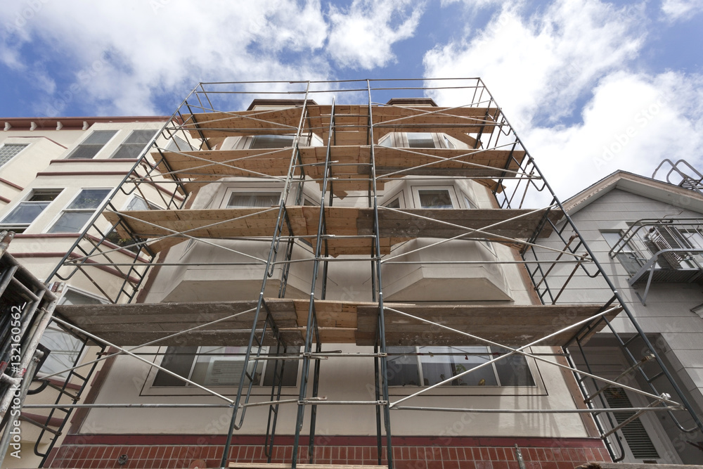 Fototapeta premium Looking up at building renovation scaffolding. Horizontal.