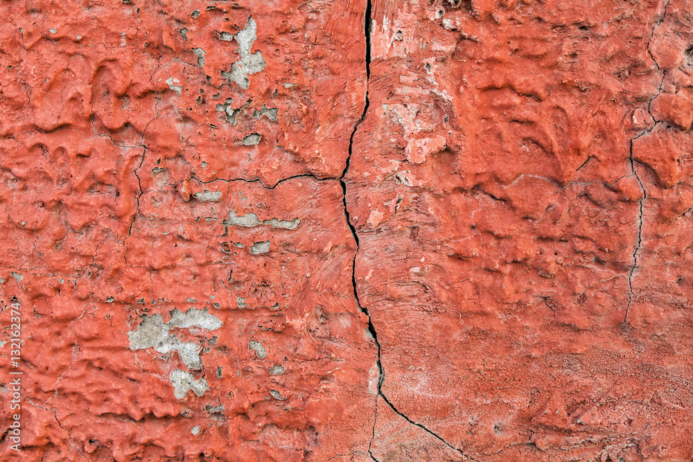 Red, plastered walls with cracks and irregularities
