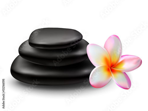 Stack of black zen stones with plumeria flower