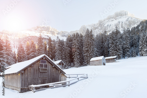 wooden house in snow covered mountains © santiago silver