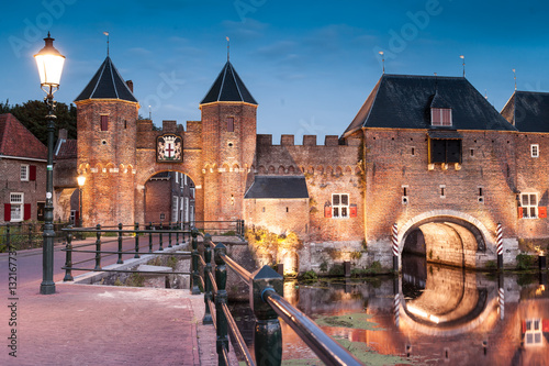 Obraz na płótnie Medieval brick city gate Koppelpoort to Dutch fortress city Amersfoort rounded by Eem river on the evening, Netherlands, Province Utrecht. w salonie
