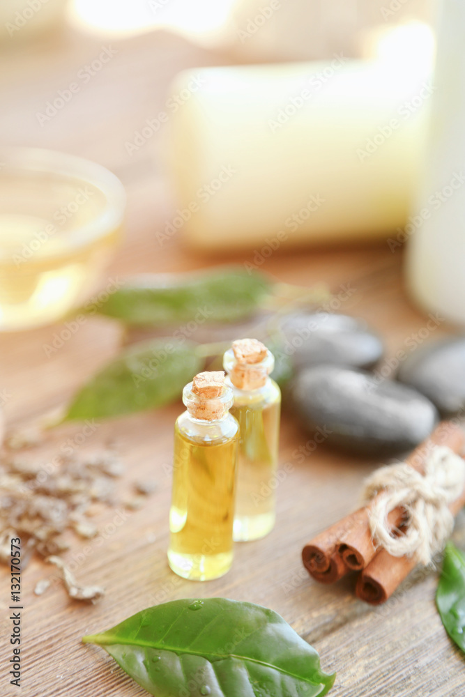 Spa composition with tea oil in small glass bottles and fresh leaves Spa composition with tea oil in small glass bottles and fresh leaves