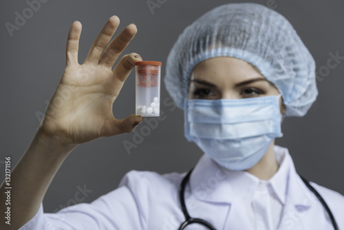 Concentrated female doctor holding a pill box