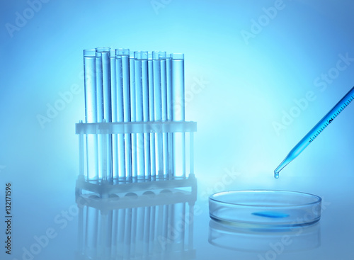 Chemical test-tubes with medicine dropper on color background