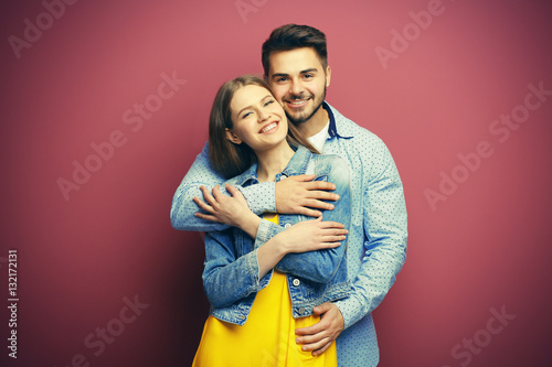 Cute young couple on color background