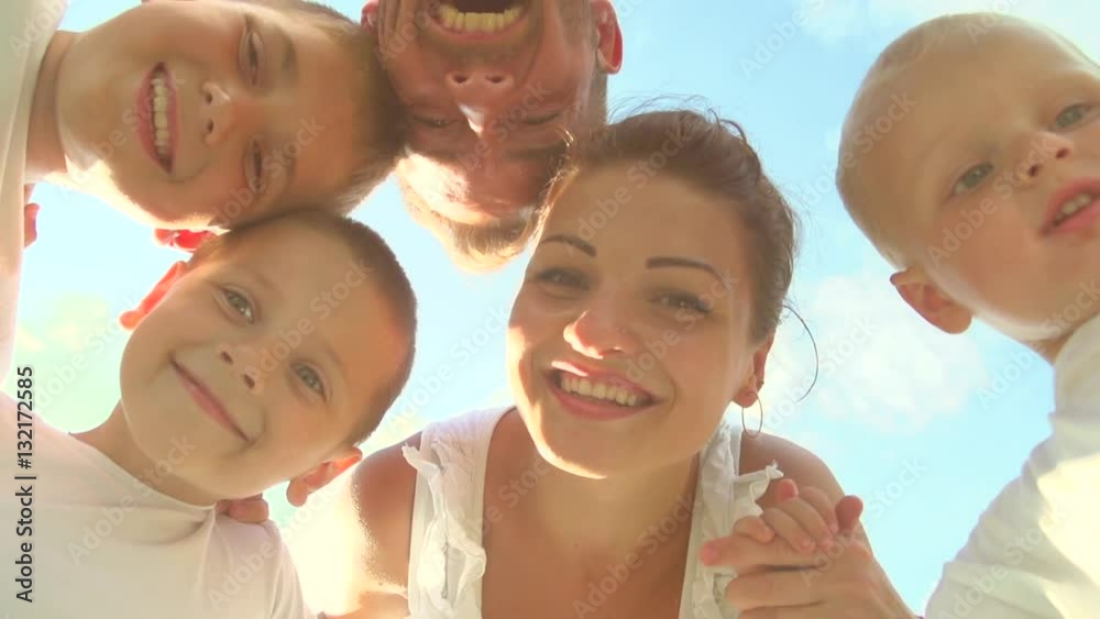 Happy laughing big family having fun outdoors. Father, mother and three children standing together in a circle over sky. Slow motion 240 fps, Full HD Happy laughing big family having fun outdoors. Father, mother and three children standing together in a circle over sky. Slow motion 240 fps, Full HD