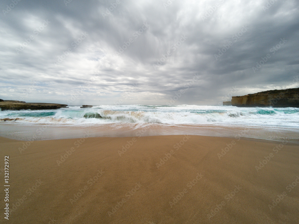 Waves rolling in on a beach at the Twelve Apostles Marine National Park, Australia