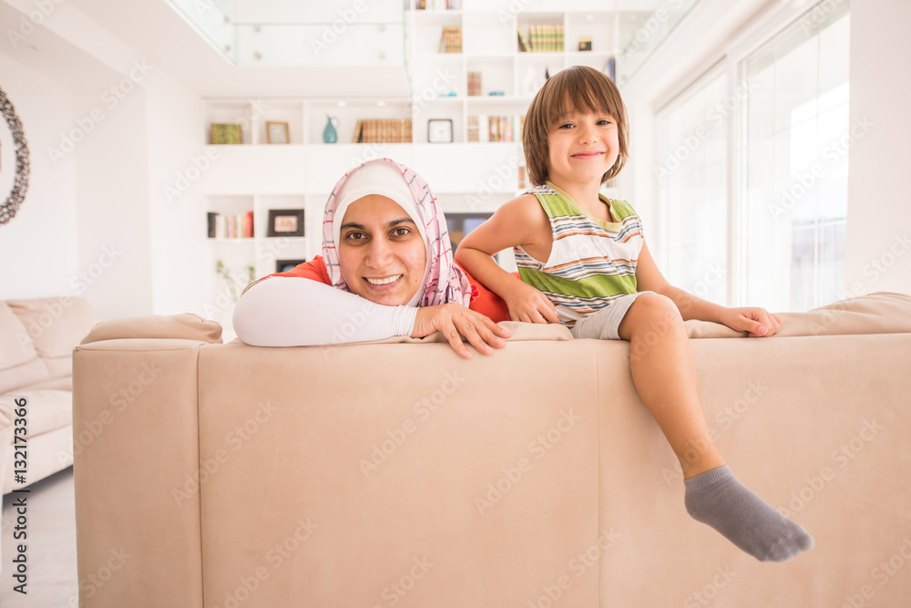 Muslim traditional mother with little cute son at home in living