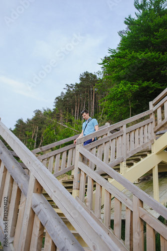 man sitting on the wooden stairs in park and smiling