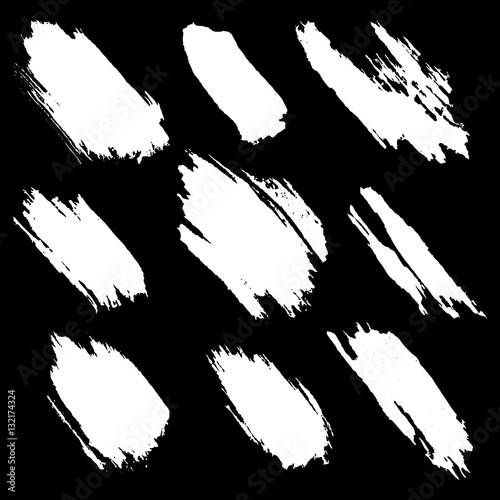 Vector set of white inc splash, blots, smudge and brush strokes, isolated on the black background. Grunge elements for design.