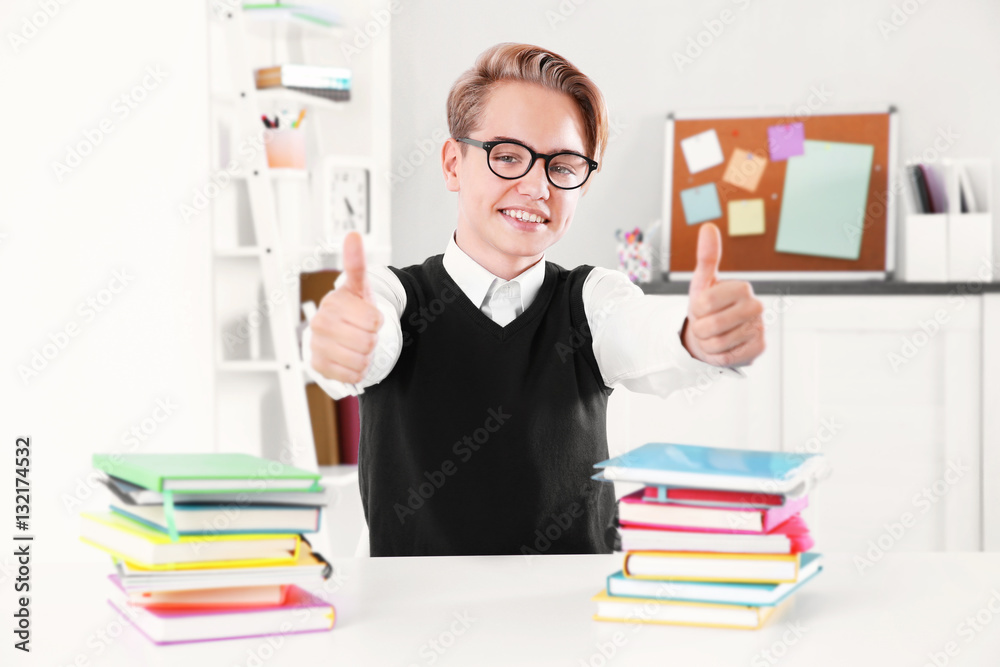 Pupil with pile of books sitting at desk in a classroom Pupil with pile of books sitting at desk in a classroom