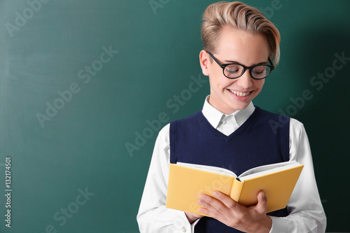 Pupil with book standing ne...