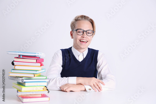 Pupil with pile of books si...
