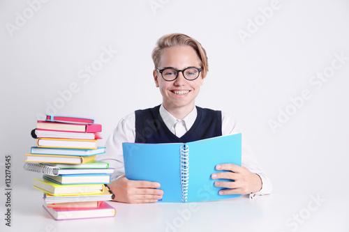 Pupil with pile of books si...