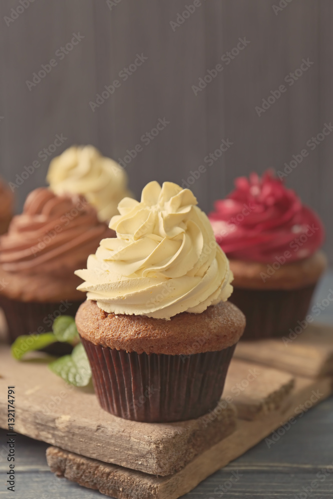 Tasty chocolate cupcake on wooden stand, close up