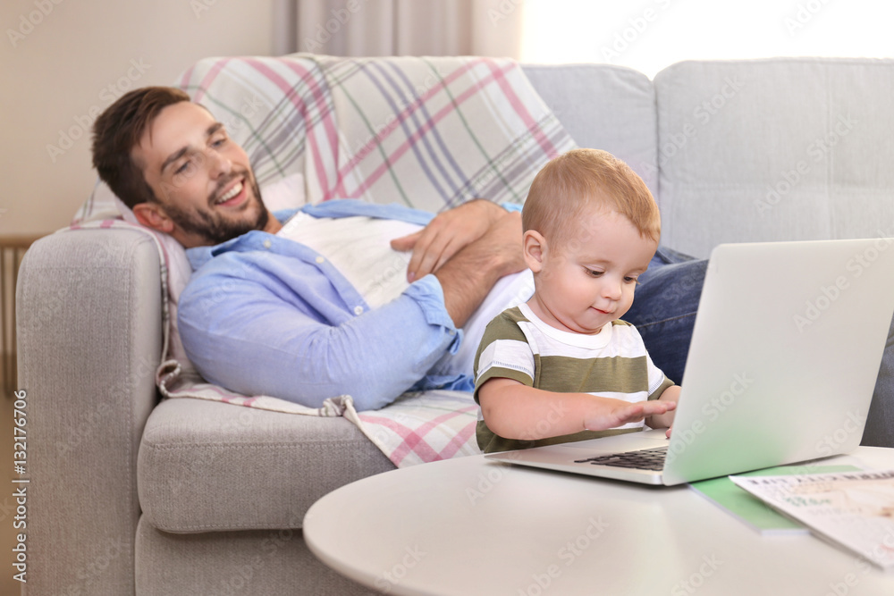 Cute baby boy using laptop under father control Cute baby boy using laptop under father control
