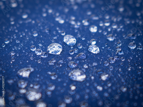 Water droplets on blue canvas