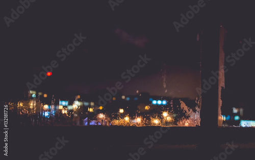 Frozen window with Blurred Defocused light of Night City, abstra