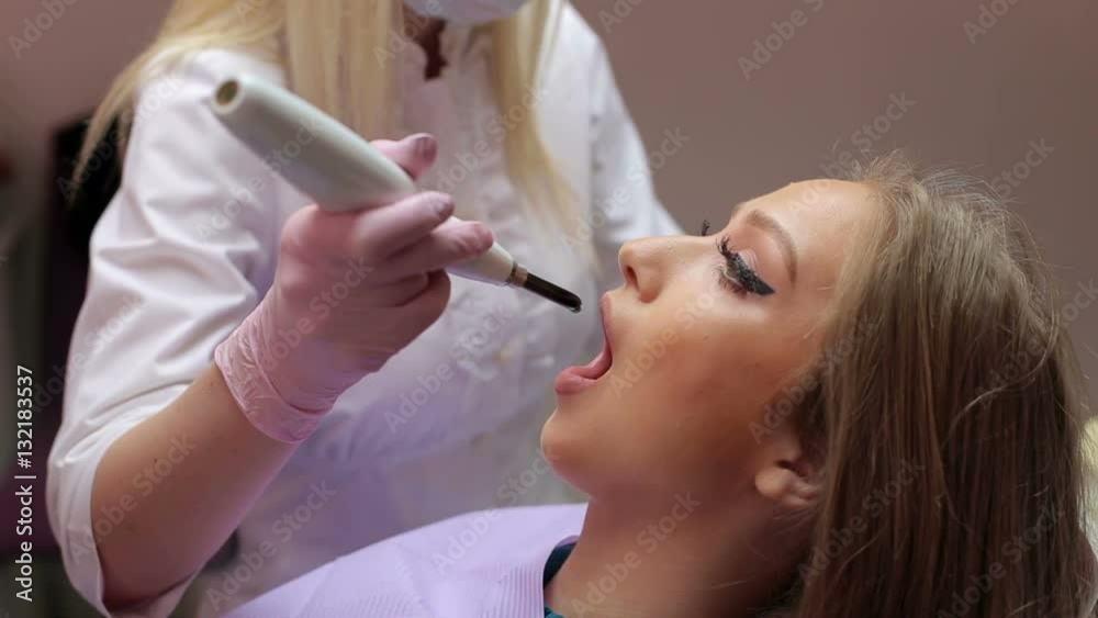 Dentist whiten teeth for a young girl in the dental clinic. Dentist whiten teeth for a young girl in the dental clinic.