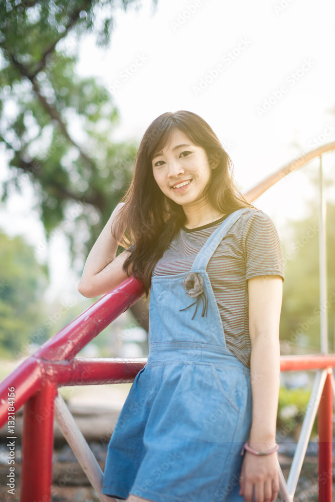 Woman relaxing on bridge enjoying her freedom wear short dress,Woman smiling happy freedom in park with sunlight