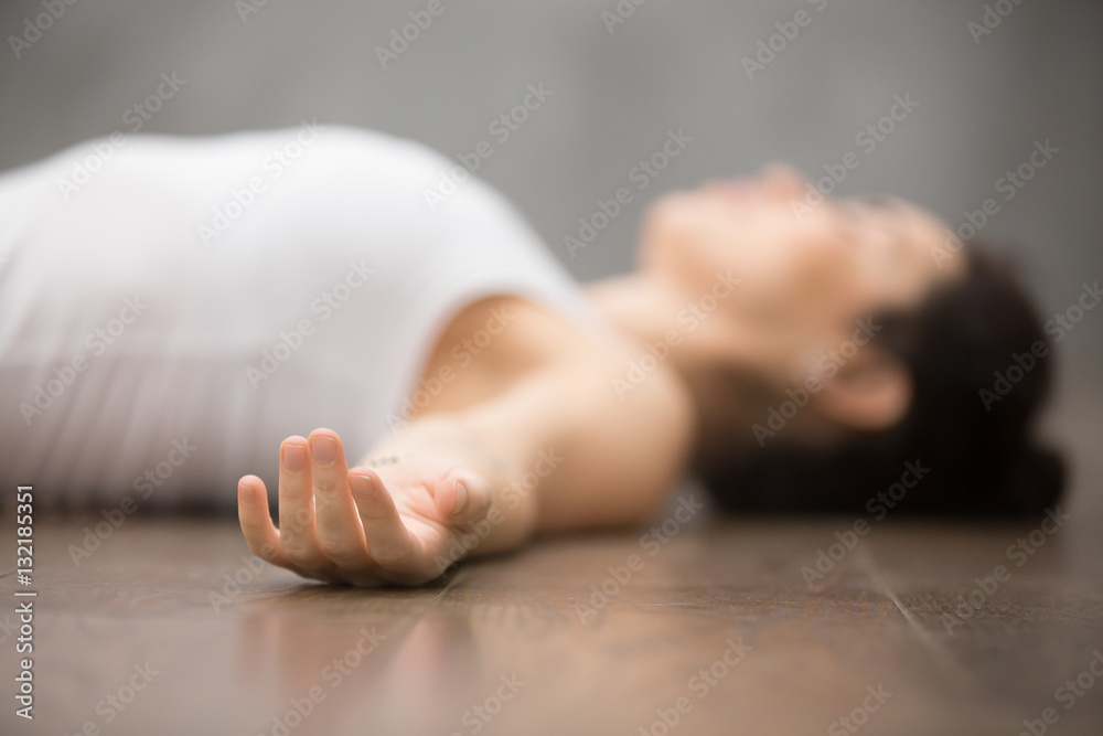 Beautiful young woman working out on wooden floor, resting after doing yoga  exercises, lying in Shavasana Corpse or Dead Body Posture , relaxing. Close  up, focus on hand Stock Photo | Adobe Stock