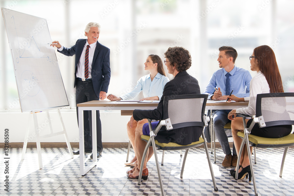 Positive senior leader drawing graph at meeting