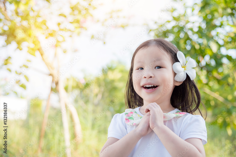 Little asian girl with flower on hair in garden Little asian girl with flower on hair in garden