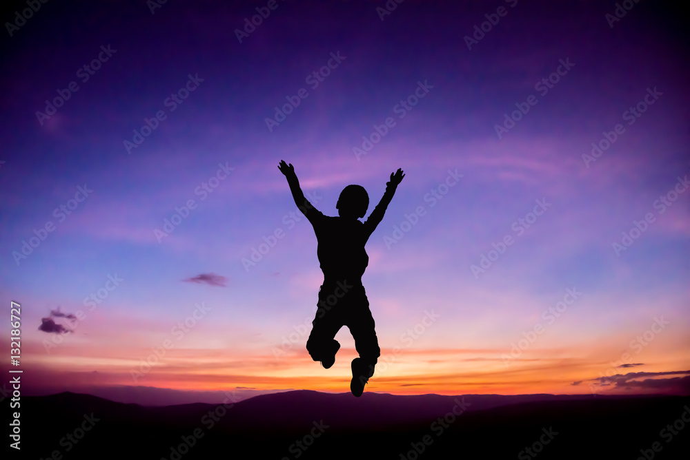 Silhouette of Child jumping up at Sunset