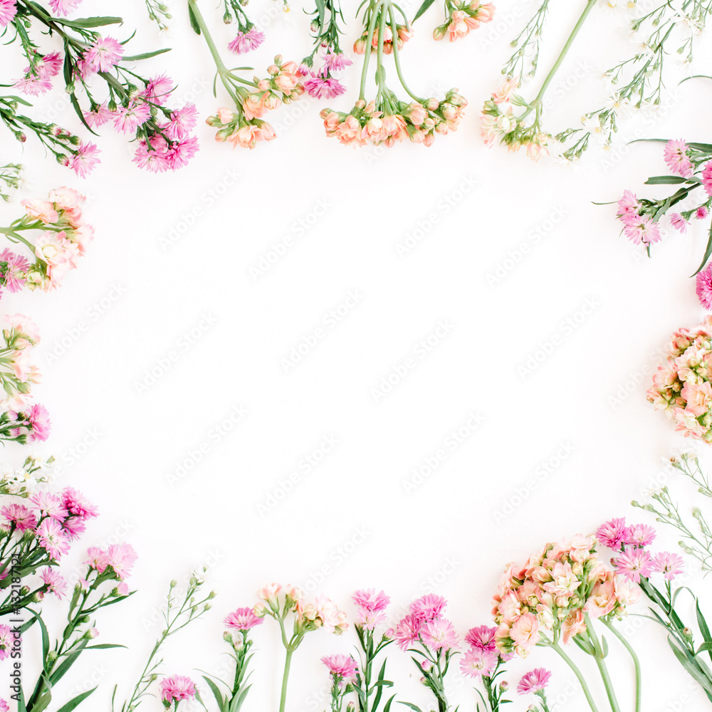 Round frame of colorful wildflowers, green leaves, branches on white background. Flat lay, top view. Valentine's background